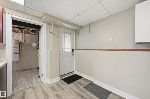 Entryway featuring wood-finish flooring, a white paneled door with decorative glass inserts, and a drop ceiling - 1729 65 Street, Edmonton, AB - Indoor Photo Showing Other Room