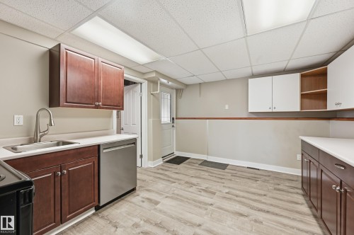 Kitchen space featuring wood-finish flooring, white countertops, and both brown and white cabinetry - 1729 65 Street, Edmonton, AB - Indoor Photo Showing Kitchen