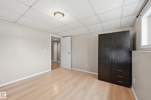 Light wood-finish flooring with a neutral wall color - 1729 65 Street, Edmonton, AB - Indoor Photo Showing Other Room