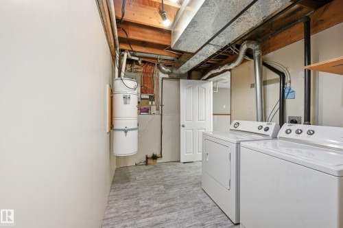 Laundry area featuring wood-finish flooring and exposed ceiling joists - 1729 65 Street, Edmonton, AB - Indoor Photo Showing Laundry Room