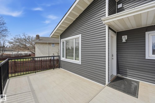 Spacious outdoor deck featuring light-toned composite decking and black metal railings - 1729 65 Street, Edmonton, AB - Outdoor With Deck Patio Veranda With Exterior