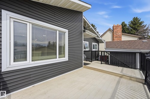 Exterior deck featuring composite decking, black aluminum railings, and dark gray horizontal siding - 1729 65 Street, Edmonton, AB - Outdoor With Deck Patio Veranda With Exterior