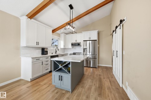 Vaulted ceiling kitchen featuring exposed wood beams and wood-finish flooring - 1729 65 Street, Edmonton, AB - Indoor Photo Showing Kitchen With Stainless Steel Kitchen