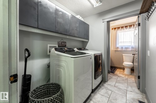 Dedicated laundry area featuring overhead cabinetry, tile flooring, and a recessed lighting fixture - 7 Doolan Place, St. Albert, AB - Indoor Photo Showing Laundry Room