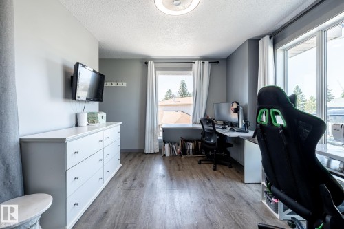 Room featuring wood-finish flooring, light gray wall paint, and multiple windows providing natural illumination - 7 Doolan Place, St. Albert, AB - Indoor Photo Showing Office