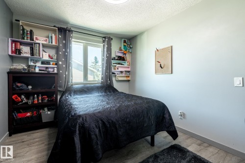 Inviting room featuring wood-finish flooring, light gray walls, and a window with natural light - 7 Doolan Place, St. Albert, AB - Indoor Photo Showing Bedroom