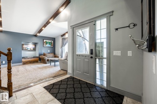 Entryway with a gray front door and sidelight, tile flooring, and a contrasting carpeted living space - 7 Doolan Place, St. Albert, AB - Indoor Photo Showing Other Room