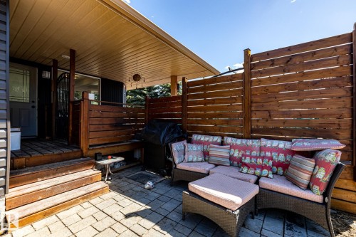 Covered patio featuring paver stone flooring, a stained wood privacy fence, and a multi-level wood deck entry - 7 Doolan Place, St. Albert, AB - Outdoor With Deck Patio Veranda With Exterior