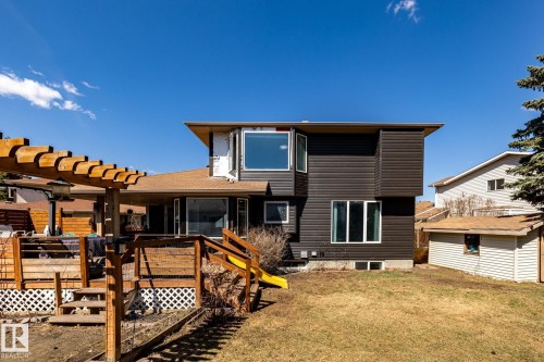 Rear exterior with a multi-level wood deck, pergola, and brown horizontal siding - 7 Doolan Place, St. Albert, AB - Outdoor With Deck Patio Veranda