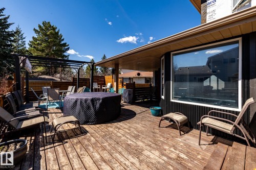 Expansive wood deck featuring a black metal pergola, privacy fencing, and a built-in hot tub - 7 Doolan Place, St. Albert, AB - Outdoor With Deck Patio Veranda With Exterior