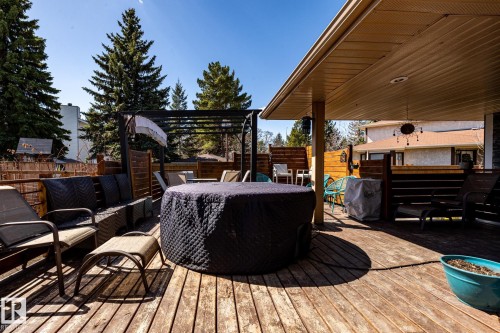 Expansive wood-decked patio featuring a covered area, privacy screens, and a built-in pergola - 7 Doolan Place, St. Albert, AB - Outdoor With Deck Patio Veranda With Exterior