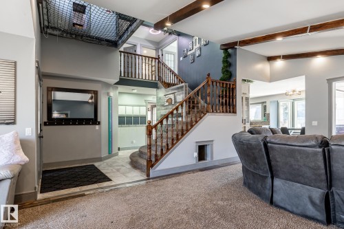 Multi-level interior featuring a wood-baluster staircase, exposed wood ceiling beams, and a tiled entryway - 7 Doolan Place, St. Albert, AB - Indoor Photo Showing Other Room