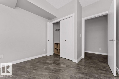 Interior space featuring wood-finish flooring and light gray painted walls - 204 10126 144 Street, Edmonton, AB - Indoor Photo Showing Other Room