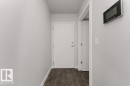 Entryway featuring wood-finish flooring, white walls, and a modern wall-mounted control panel - 204 10126 144 Street, Edmonton, AB  - Indoor Photo Showing Other Room 