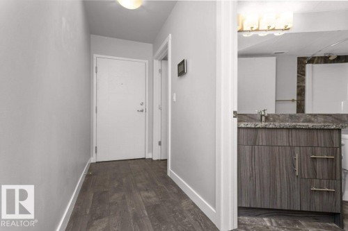 Hallway featuring wood-finish flooring, light gray walls, and a recessed ceiling light - 204 10126 144 Street, Edmonton, AB - Indoor Photo Showing Other Room