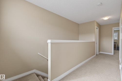 Carpeted hallway with neutral wall tones and white baseboards - 17 171 Brintnell Boulevard, Edmonton, AB - Indoor Photo Showing Other Room