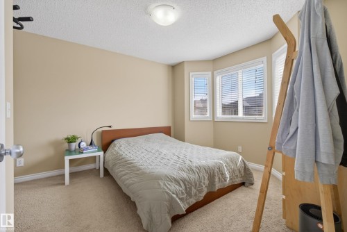 Carpeted room featuring a bay window with blinds, neutral wall tones, and a ceiling-mounted light fixture - 17 171 Brintnell Boulevard, Edmonton, AB - Indoor Photo Showing Bedroom
