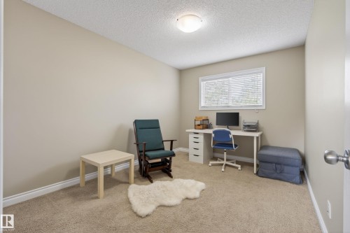 Versatile room featuring neutral beige walls, light-colored carpeting, a single window with white blinds, and a flush-mount ceiling light fixture - 17 171 Brintnell Boulevard, Edmonton, AB - Indoor