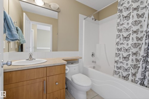 Bathroom featuring a light wood-finish vanity, integrated sink, and stone-finish countertop - 17 171 Brintnell Boulevard, Edmonton, AB - Indoor Photo Showing Bathroom
