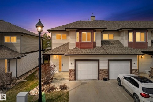 Townhome exterior featuring light-colored siding, dark shingles, and stone accents - 17 171 Brintnell Boulevard, Edmonton, AB - Outdoor