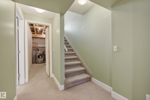Carpeted stairway and hallway featuring white trim and light green wall paint - 17 171 Brintnell Boulevard, Edmonton, AB - Indoor Photo Showing Other Room