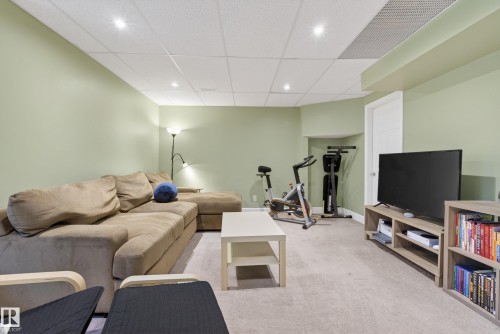 Spacious room featuring light green walls and light grey carpeting, recessed ceiling lighting, and a white paneled door - 17 171 Brintnell Boulevard, Edmonton, AB - Indoor