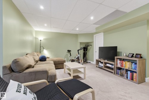 Spacious carpeted room featuring recessed lighting, a drop ceiling, and light green walls - 17 171 Brintnell Boulevard, Edmonton, AB - Indoor