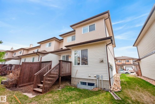 Rear exterior featuring a multi-level wood deck, light-colored siding, and a wooden privacy fence - 17 171 Brintnell Boulevard, Edmonton, AB - Outdoor