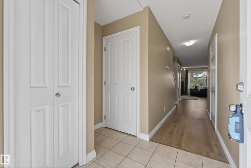 Entryway featuring light-toned tile flooring transitioning to wood-finish flooring - 17 171 Brintnell Boulevard, Edmonton, AB - Indoor Photo Showing Other Room