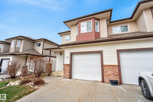 Two-story townhouse exterior with light-colored siding, contrasting darker trim, and a prominent bay window with reddish-brown siding - 17 171 Brintnell Boulevard, Edmonton, AB - Outdoor