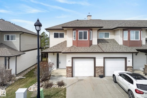Townhome exterior featuring white siding, brown accents, and stone-look detailing - 17 171 Brintnell Boulevard, Edmonton, AB - Outdoor With Facade