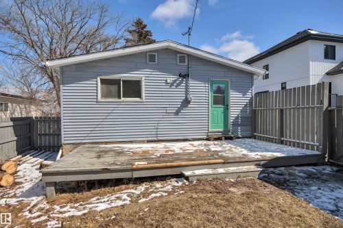 Exterior featuring light blue horizontal siding, a green entry door, and an elevated wooden deck - 4712 49 Street, Calmar, AB - Outdoor With Exterior