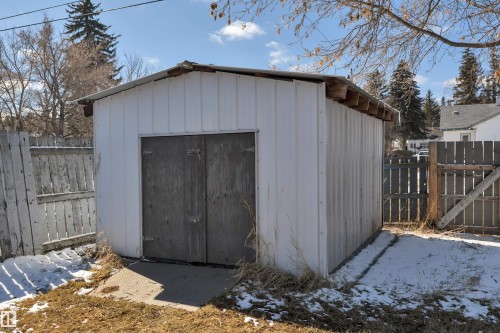 Freestanding storage shed with white panel siding and wood-finish double doors - 4712 49 Street, Calmar, AB - Outdoor With Exterior