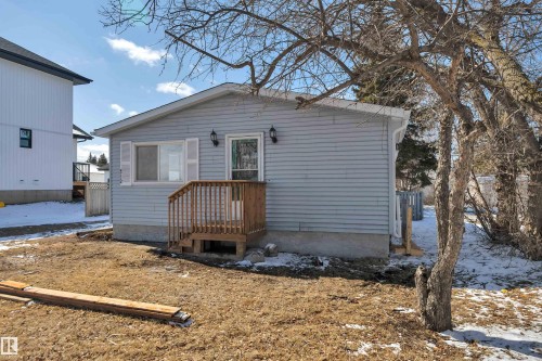 Light blue horizontal siding exterior with a wood entry deck and white window shutters - 4712 49 Street, Calmar, AB - Outdoor With Exterior