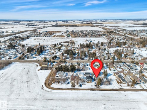 Aerial view of a residential area featuring multiple detached homes and surrounding agricultural fields - 4712 49 Street, Calmar, AB - Outdoor With View