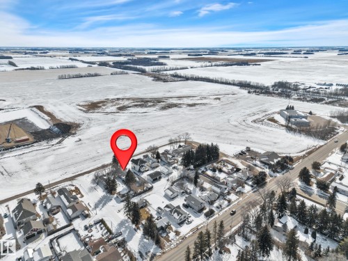 Aerial overview showcasing a residential neighborhood bordering expansive snow-covered fields - 4712 49 Street, Calmar, AB - Outdoor With View