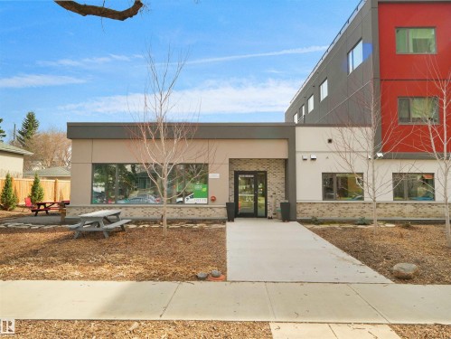 Contemporary building facade featuring a prominent glass entrance and varied exterior finishes - 403 10115 88 Avenue, Edmonton, AB - Outdoor