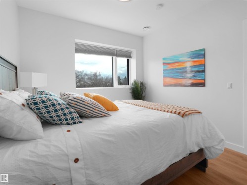 Bedroom featuring a large picture window, recessed ceiling lighting, and wood-finish flooring - 403 10115 88 Avenue, Edmonton, AB - Indoor Photo Showing Bedroom