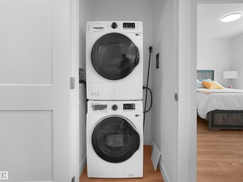 Laundry closet featuring a stacked white washer and dryer unit - 403 10115 88 Avenue, Edmonton, AB - Indoor Photo Showing Laundry Room
