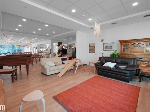 Spacious open-concept interior featuring light wood-finish flooring, recessed lighting, and a neutral color palette - 403 10115 88 Avenue, Edmonton, AB - Indoor