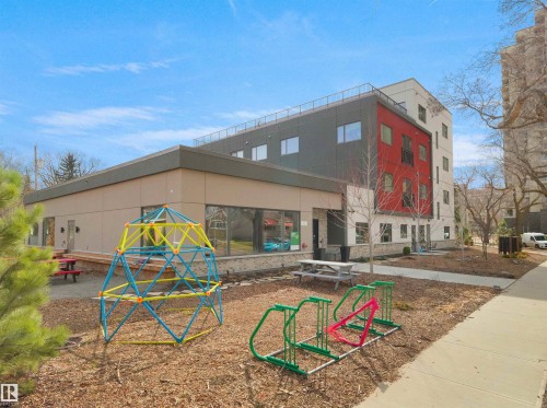 Modern multi-story building featuring a red and gray facade with multiple windows - 403 10115 88 Avenue, Edmonton, AB - Outdoor
