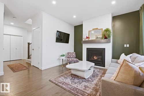 Living area featuring wood-look flooring, a fireplace with a mantel, and recessed lighting - 405 Genesis Court, Stony Plain, AB - Indoor Photo Showing Living Room With Fireplace