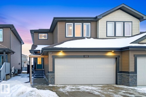 The property features a two-story exterior with multi-toned siding, a large garage, and a welcoming front entrance - 405 Genesis Court, Stony Plain, AB - Outdoor