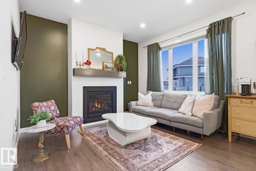 Living room featuring a modern fireplace, a large window, recessed lighting, and hardwood flooring - 405 Genesis Court, Stony Plain, AB - Indoor Photo Showing Living Room With Fireplace