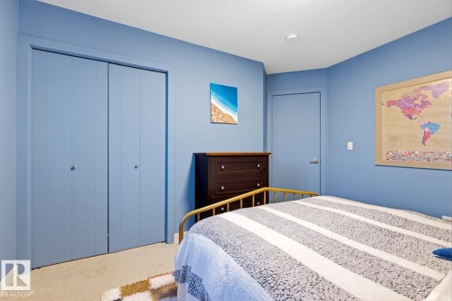 This room features blue walls and light-colored carpeting - 405 Genesis Court, Stony Plain, AB - Indoor Photo Showing Bedroom