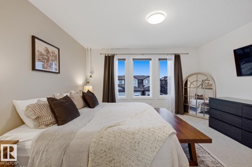 This room features light-colored walls and three windows providing natural light - 405 Genesis Court, Stony Plain, AB - Indoor Photo Showing Bedroom
