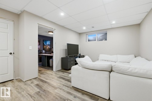 This versatile area features light-toned walls and wood-look flooring, creating a bright and inviting space - 405 Genesis Court, Stony Plain, AB - Indoor Photo Showing Basement