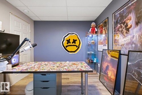 Versatile room featuring wood-look flooring, a white door, and a drop ceiling - 405 Genesis Court, Stony Plain, AB - Indoor Photo Showing Other Room