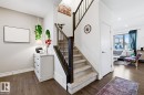 The property features hardwood flooring and a carpeted staircase with dark wood railings - 405 Genesis Court, Stony Plain, AB  - Indoor Photo Showing Other Room 