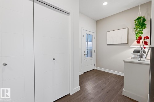 Entryway featuring dark hardwood flooring, a white front door with glass panels, and white closet doors with chrome handles - 405 Genesis Court, Stony Plain, AB - Indoor Photo Showing Other Room